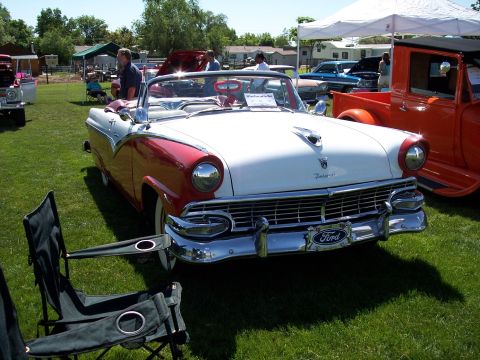 1972 Ford Ranchero - A classic red and white Ford Fairlane convertible is displayed on a grassy field with other vehicles and tents.