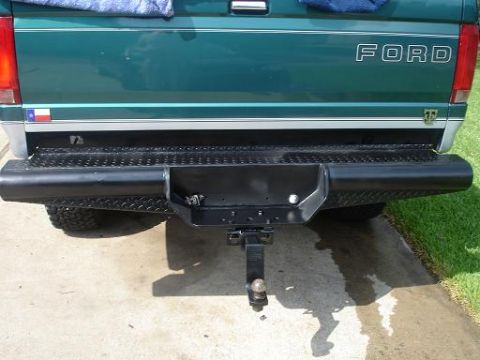 1996 Ford F-150 - The rear of a green 1996 Ford F-150 pickup truck is shown with a black diamond plate bumper.