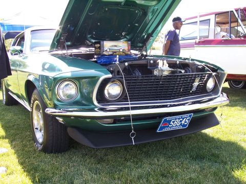 1972 Ford Ranchero - A green 1969 Ford Mustang is displayed with its hood up at an outdoor event.