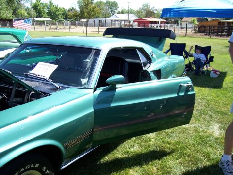 1972 Ford Ranchero - A green 1970 Mustang Mach 1 is displayed with its door open at an outdoor event.