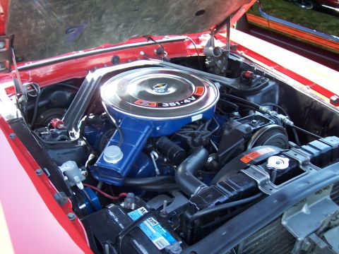 1972 Ford Ranchero - The engine bay of a red 1972 Ford Ranchero is visible, a 351-4V engine and chrome air cleaner.