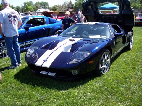 1972 Ford Ranchero - A blue Ford GT with white racing stripes is displayed with its doors open at an outdoor car show.