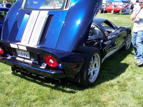 1972 Ford Ranchero - A blue Ford GT is displayed with its rear hood open, revealing the engine compartment. White racing stripes adorn the car's body.