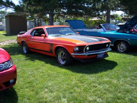 1972 Ford Ranchero - An orange 1969 Ford Mustang Boss 302 is parked on grass next to other vehicles.
