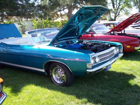 1972 Ford Ranchero - A teal 1970 Ford Torino GT convertible is displayed with its hood open at an outdoor car show.