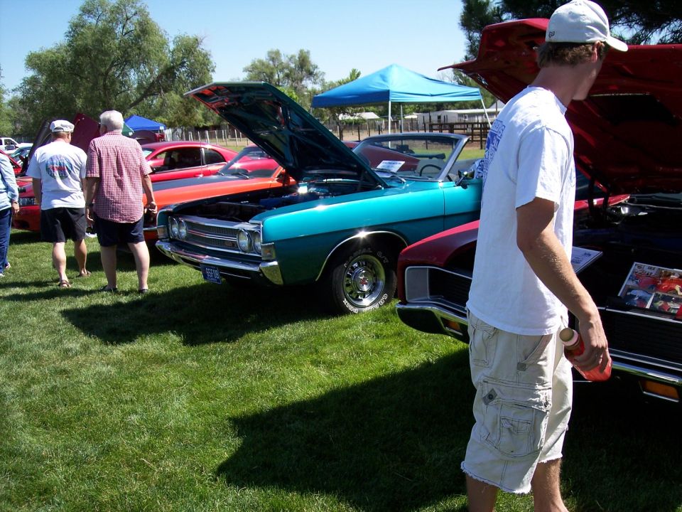 Teal 1970 Ford Ranchero convertible with hood open, parked on grass