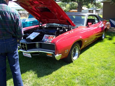 1972 Ford Ranchero - A red 1970 Mercury Cougar XR7 is displayed with its hood open at an outdoor event.