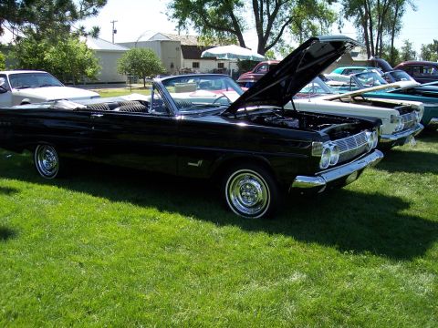 1972 Ford Ranchero - A black 1965 Mercury Comet convertible is displayed with its hood open at an outdoor car show.