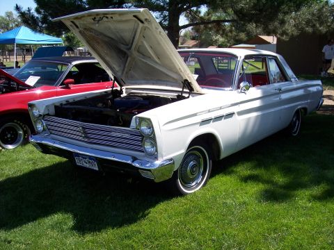 1972 Ford Ranchero - A white 1965 Mercury Comet is displayed with its hood open, parked on a grassy lawn next to another vehicle.