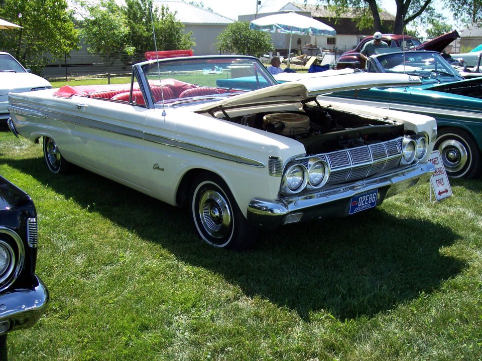 White 1964 Comet convertible with red interior, hood open, parked on grass