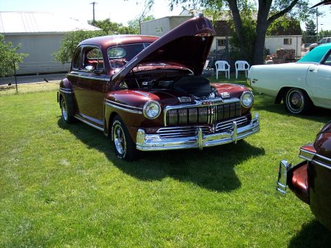 1972 Ford Ranchero - A maroon 1949 Mercury coupe is parked on a grassy lawn with its hood open, revealing the engine.