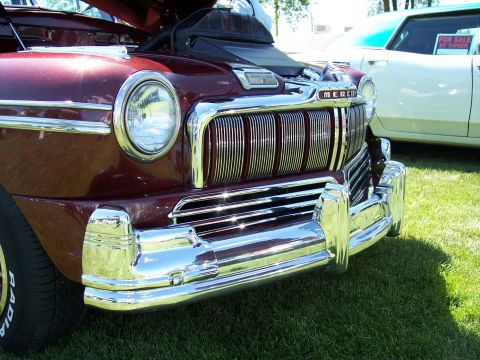 1972 Ford Ranchero - A maroon Mercury car's front end is displayed, with a prominent chrome grille and bumper. A white car with a "FOR SALE BY OWNER" sign is vi…