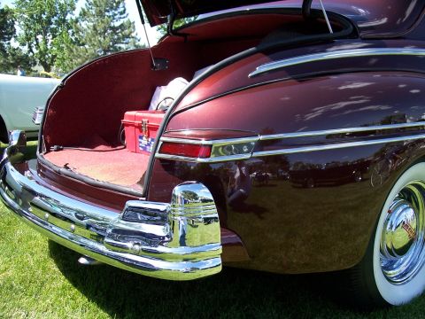 1972 Ford Ranchero - Trunk interior of a classic car, a red carpet and a red toolbox inside.