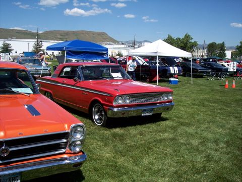 1972 Ford Ranchero - A red 1962 Ford Galaxie is parked on a grassy field at an outdoor car show.