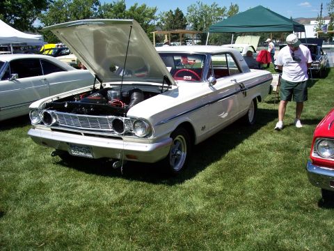 1972 Ford Ranchero - A white 1964 Ford Falcon Futura coupe is displayed with its hood open at an outdoor event.