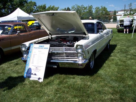 1972 Ford Ranchero - A white 1967 Ford Fairlane 500XL is displayed with its hood open, next to a brown vehicle.