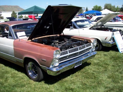 1972 Ford Ranchero - A copper and white Ford Ranchero is displayed with its hood open, alongside other vehicles at an outdoor event.