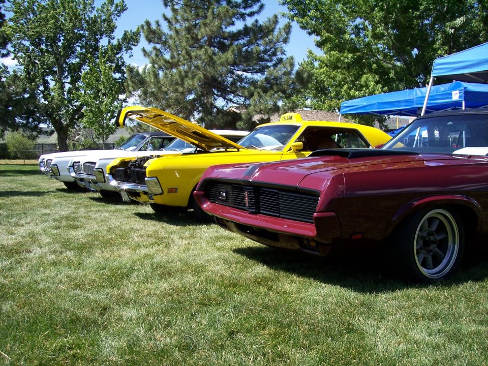 Maroon 1970 Mercury Cougar front end with black grille, parked in a line with other classic cars