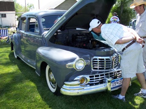 1972 Ford Ranchero - Two men examine the engine of a classic 1940s Lincoln Continental at an outdoor gathering.