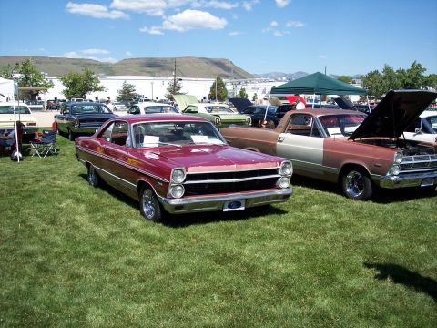 1972 Ford Ranchero - A maroon 1966 Ford Ranchero is parked on a grassy field next to a two-tone pickup truck.