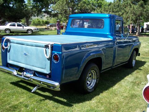 1972 Ford Ranchero - Blue 1957 Ford F-100 pickup truck with a custom tonneau cover and chrome bumper, parked on grass.