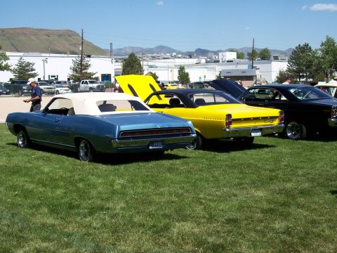 1972 Ford Ranchero - Three classic cars are parked on a grassy field under a clear blue sky.