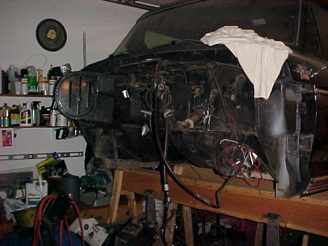 Truck front end disassembled, showing engine bay and wiring