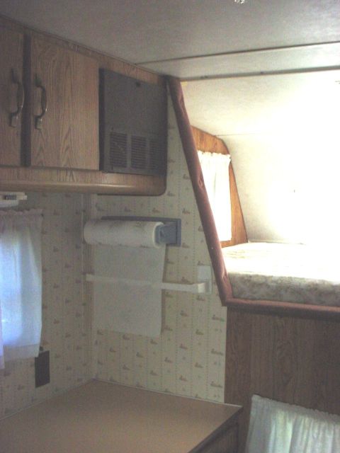 2000 Ford Taurus - The interior of a recreational vehicle shows a sleeping area and storage cabinets.