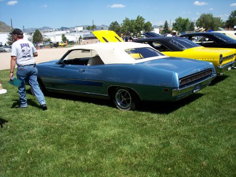 1972 Ford Ranchero - A blue 1972 Ford Ranchero convertible is parked on grass next to other vehicles at an outdoor event.