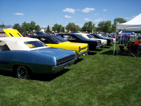 1972 Ford Ranchero - Several classic cars, including a 1972 Ford Ranchero, are displayed on a grassy field under a blue sky.