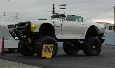 1981 Ford Bronco - This heavily modified vehicle features a car body atop a monster truck chassis with oversized tires.