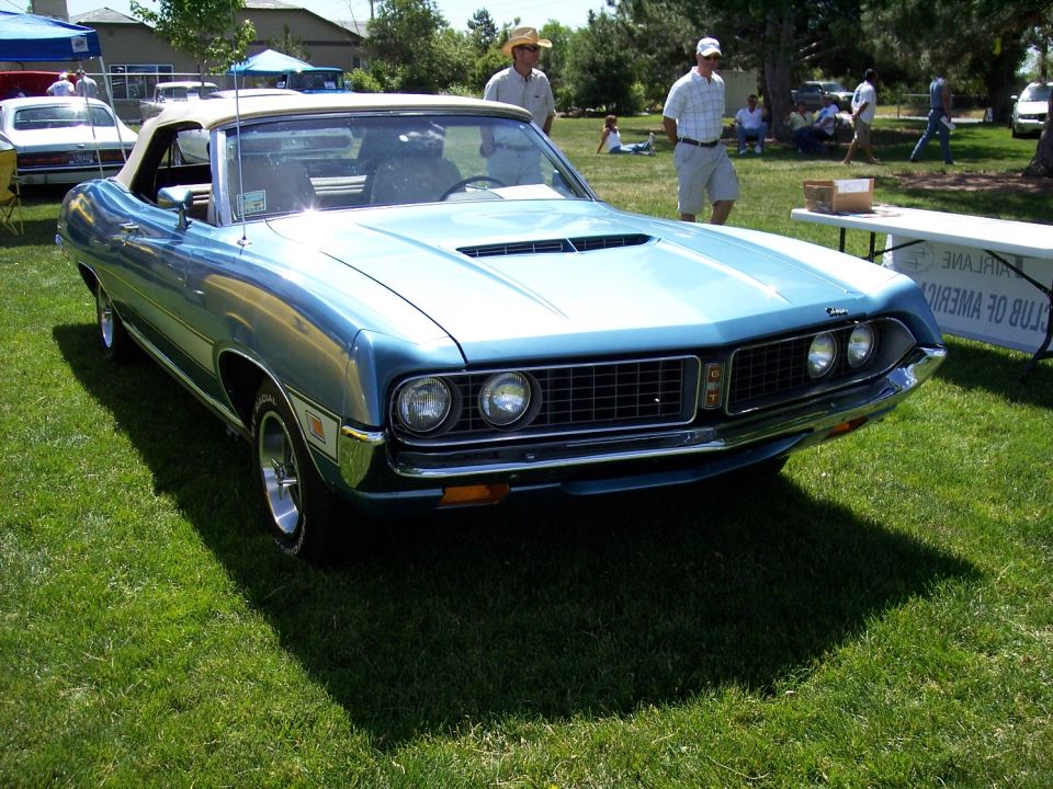 Blue 1970 Ford Torino GT convertible with a white top, parked on grass