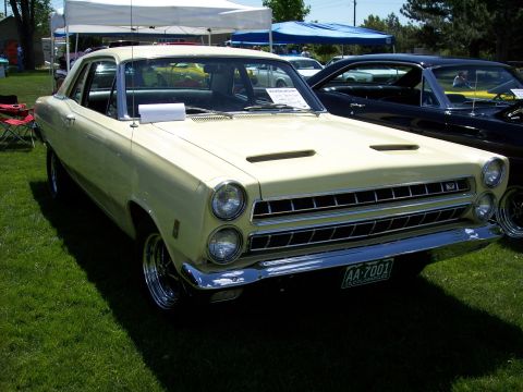 1972 Ford Ranchero - A pale yellow 1967 Mercury Cougar is displayed at an outdoor event with other vehicles present.