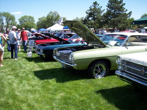 1972 Ford Ranchero - Several classic cars are displayed on a grassy field under a clear blue sky.