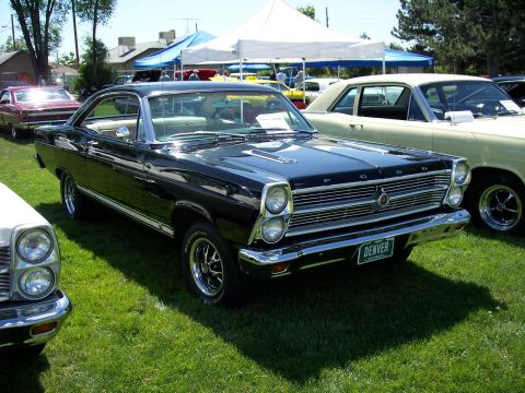 1972 Ford Ranchero - A black 1967 Ford Ranchero is parked on grass next to other vehicles at an outdoor event.