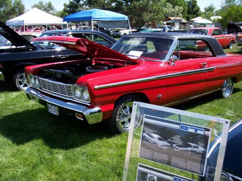 1972 Ford Ranchero - Red 1965 Ford Galaxie 500 coupe on display at a car show, with its hood up.