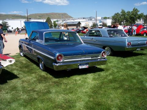 1972 Ford Ranchero - A blue 1964 Ford coupe is parked on grass with its hood open, next to another classic car.