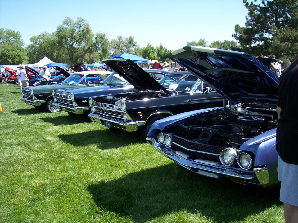Blue 1968 Ford Torino front view, hood open, parked on grass at car show