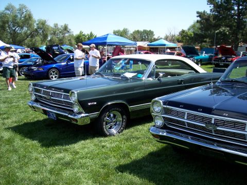 1972 Ford Ranchero - A green 1966 Ford Fairlane convertible is displayed at an outdoor car show next to a dark blue car.