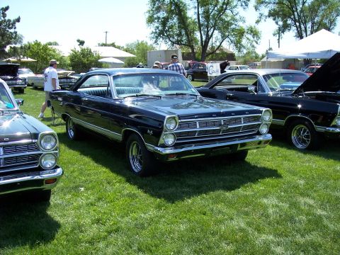 1972 Ford Ranchero - A lineup of classic Ford vehicles are displayed on a sunny day at an outdoor event.