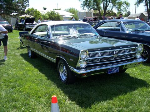 1972 Ford Ranchero - A dark green 1967 Ford Ranchero with a white roof is displayed at an outdoor event.