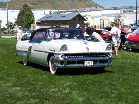 1972 Ford Ranchero - White 1955 Mercury Montclair convertible at a car show with other vehicles in the background.