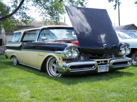 1972 Ford Ranchero - A classic two-tone Mercury station wagon is displayed with its hood open on a grassy field.