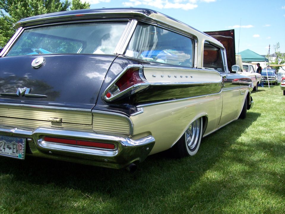 1958 Mercury Voyager station wagon rear quarter view, two-tone paint, lowered suspension. Other cars visible in background
