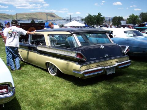 1972 Ford Ranchero - A classic Mercury wagon is displayed at a car show with other vehicles and tents in the background.