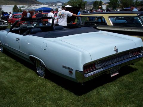 1972 Ford Ranchero - A light blue convertible parked on grass at an outdoor event with other vehicles present.