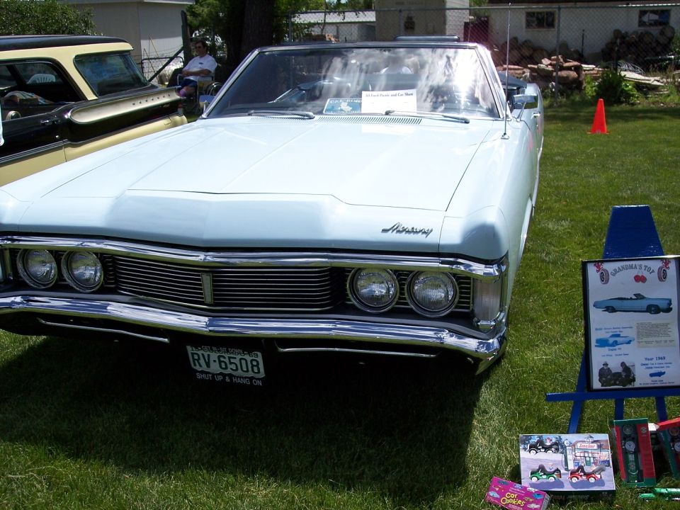 Light blue convertible with a prominent grille and dual headlights. License plate RV-6508