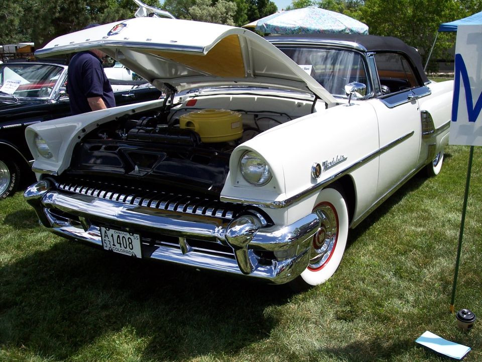 1956 Mercury Montclair convertible with hood open, showing engine. Another car is partially visible to the left