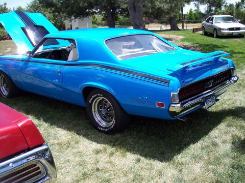 1972 Ford Ranchero - Blue 1970 Mercury Cougar Eliminator parked on grass with hood open; another vehicle in foreground.