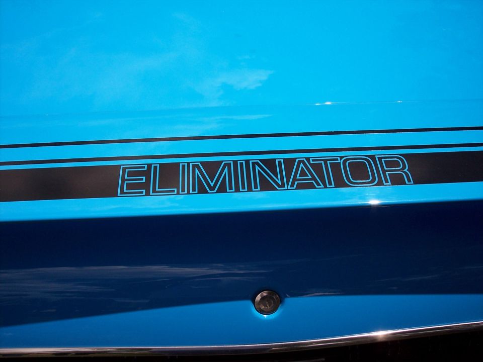 Close-up of a blue car's side with a black stripe that says "ELIMINATOR" in blue outline